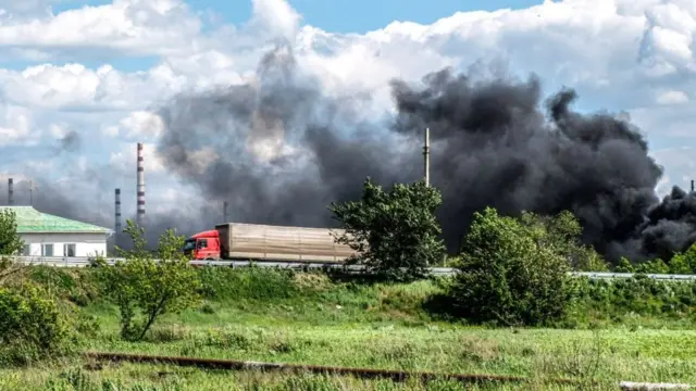 Smoke rises from a bombed oil refinery in Lysychansk, 27 May