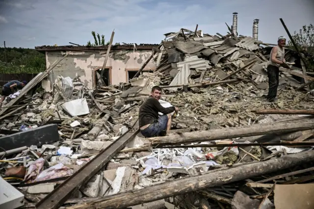 A man sits in the debris of a destroyed house in the city of Slovyansk in the Donbas region