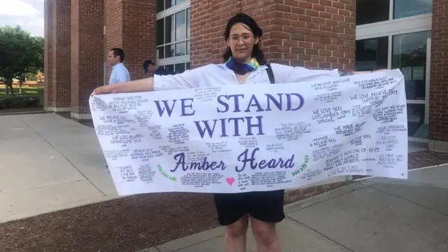 Sydni Porter displays a flag with messages from Amber Heard fans