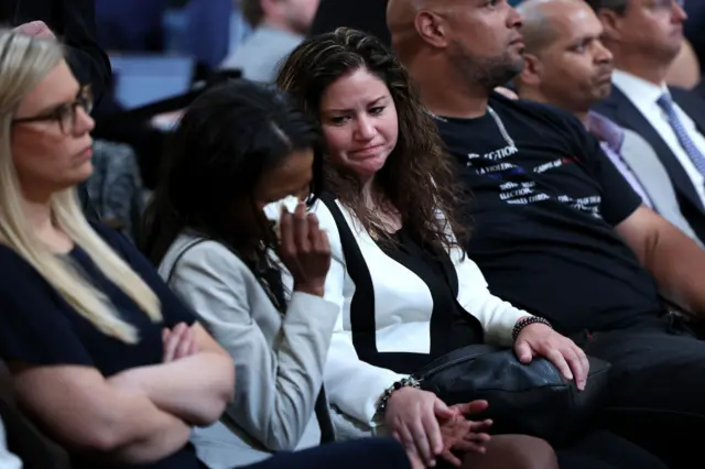 Sandra Garza comforts audience member at committee hearing.