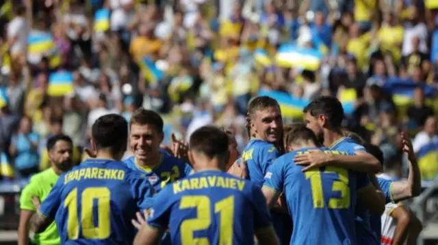 Ukraine's Ruslan Malinovskyi celebrates scoring their first goal with teammates