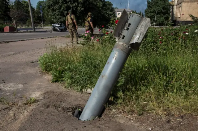 An unexploded shell of a multiple rocket launch system is seen stuck in the ground