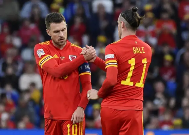 Gareth Bale shakes hands with Aaron Ramsey as he goes off