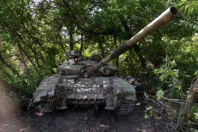 A Ukrainian serviceman sits inside a tank at a position in Donetsk region