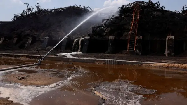 Piles of burnt sunflower seed meal are pictured at a destroyed area of the Nika-Tera grain terminal,