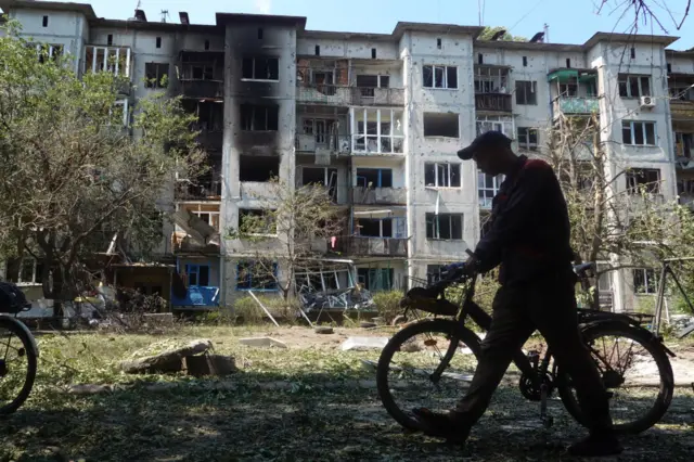 A resident walks between apartment blocks in Bakhmut, Ukraine