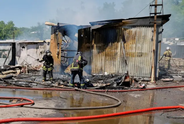 Firefighters extinguish a fire at the central Maisky market