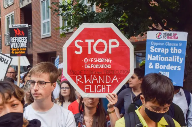 A protester holds a 'Stop Rwanda flight' placard during the demonstration