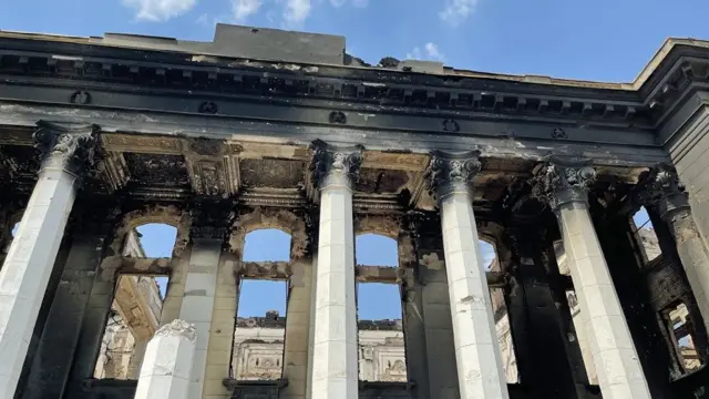 The columns of the Palace of Culture are now charred and broken