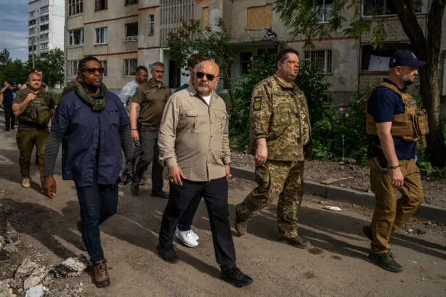 Karim Khan, centre, visits the heavily-shelled Saltivka neighbourhood in Kharkiv