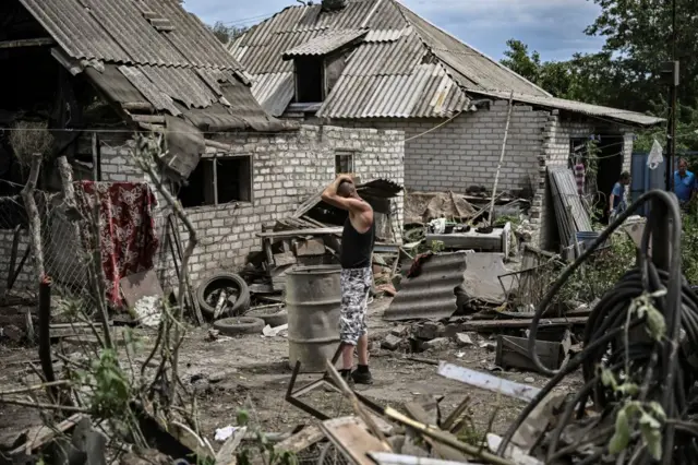 Maksym Katerin stands in the yard of his damaged house after his mother and his step father were killed during shelling in the city of Lysychansk in the eastern Ukrainian region of Donbas on 13 June 13