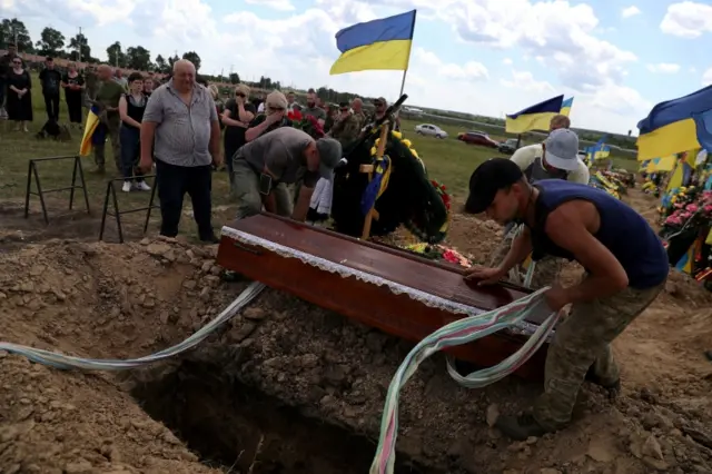 The casket of Evgeny Khrapko is buried in Kharkiv