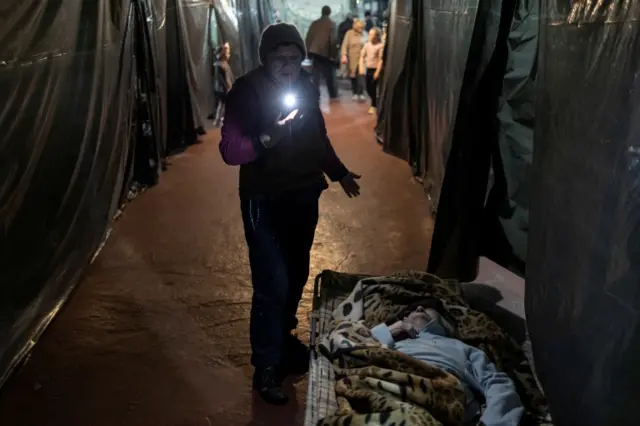 Two women - one lying, one standing - inside Azot chemical plant"s bomb shelter