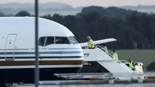 People in high-vis jackets boarding plane