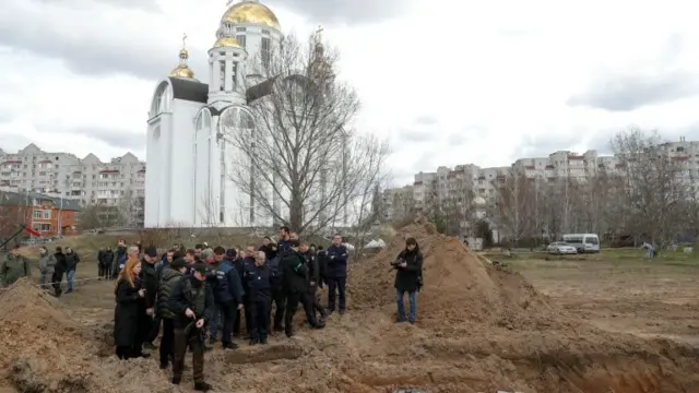 French forensics investigators, who arrived to Ukraine for the investigation of war crimes amid Russia"s invasion, stand next to a mass grave in the town of Bucha, in Kyiv region, Ukraine April 12, 2022