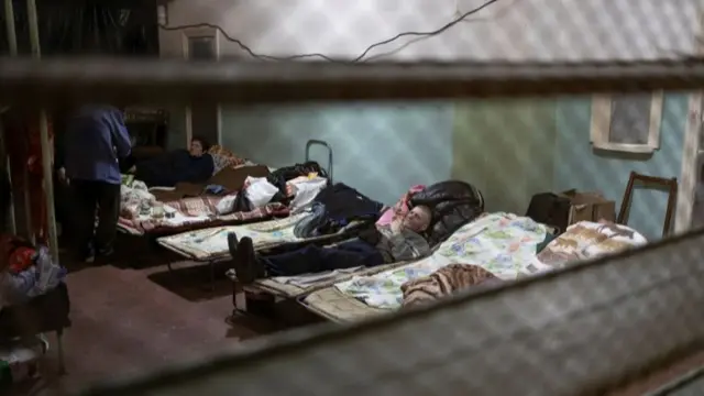 People lie in beds inside Azot chemical plant"s bomb shelter, where people have been hiding from from shelling since the beginning of the war, in Severodonetsk, Luhansk region