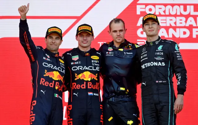 Sergio Perez, Max Verstappen, a Red Bull team member and George Russell on the podium in Baku