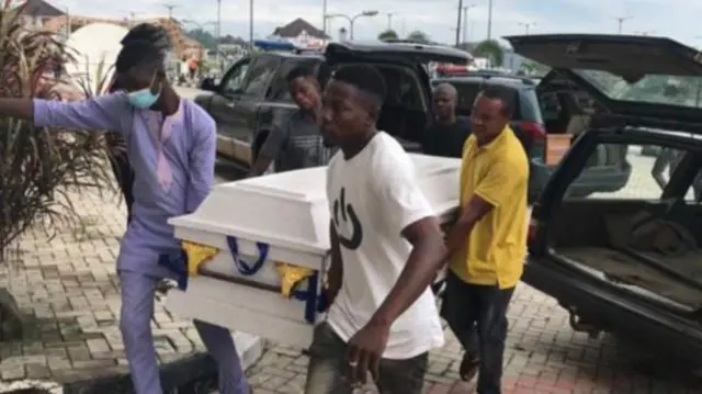 People carrying a coffin in Owo, Nigeria