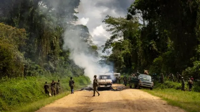 Congolese Army Soldiers and UN troops inspect an ambush site where an hour previously ADF fundamentalist rebels attacked two vehicles on the road between Beni and the Ugandan border town of Kasindi, on April 9, 2021