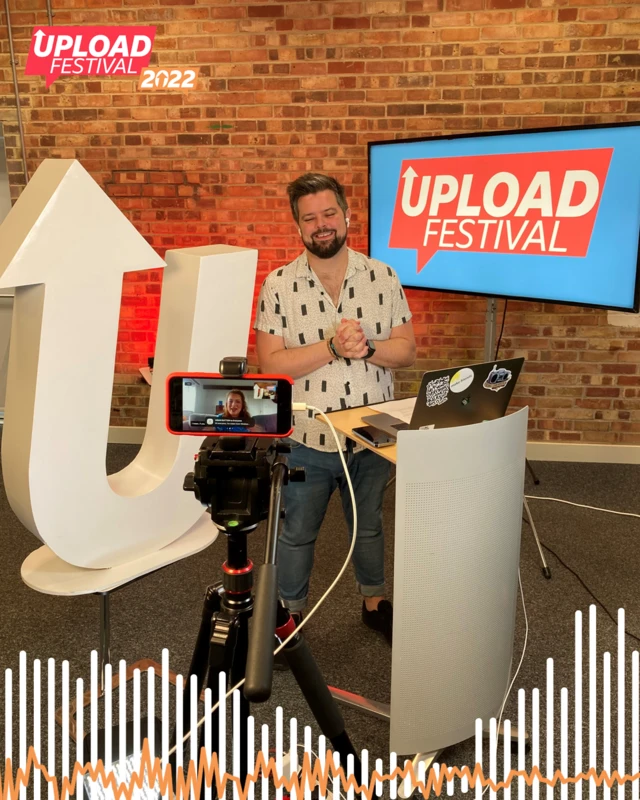 Adam Crowther, the BBC Radio Bristol Upload presenter standing at a podium.