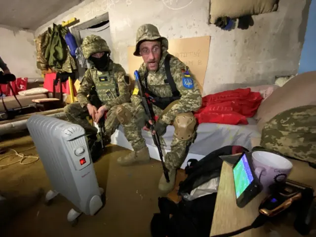 Members of the Ukrainian Territorial Defense Forces watch the playoff in Kharkiv