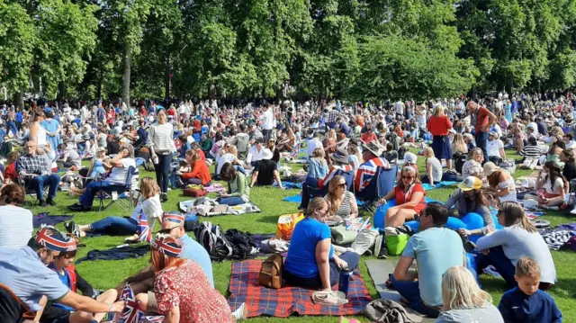 A sea of spectators sit in St James's Park