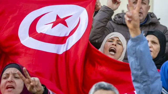 Tunisians shout slogans and hold national flags during a protest against Tunisian President Kais Saied in Tunis, Tunisia on April 10, 2022.