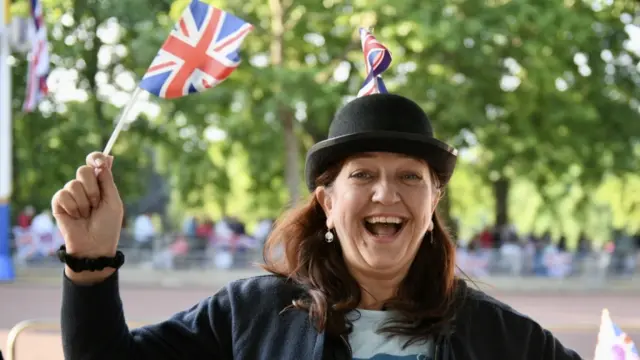 Member of the public Kerry Russell wears a bowler hat impaled with a Union flag