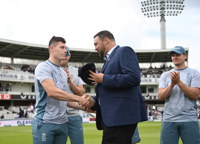 Matty Potts (left) is presented with his Test cap by former England bowler Steve Harmison (right)