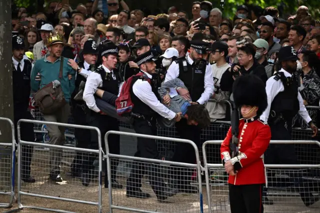 British police escort protestors away from the Mall during the Queen's Birthday Parade, the Trooping the Colour