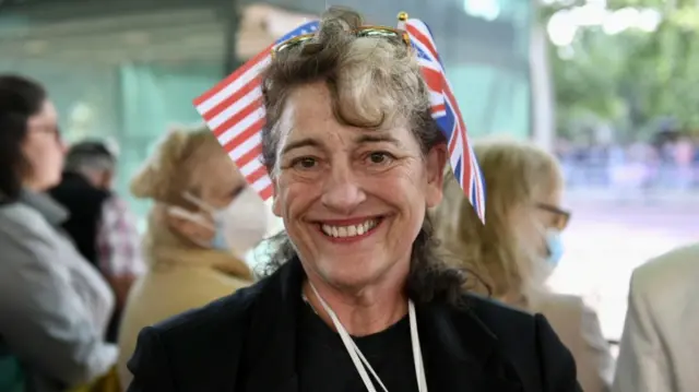 Member of the public Elaine Henderson, from the US, wears a small version of her country's flag and a Union Jack in her hair