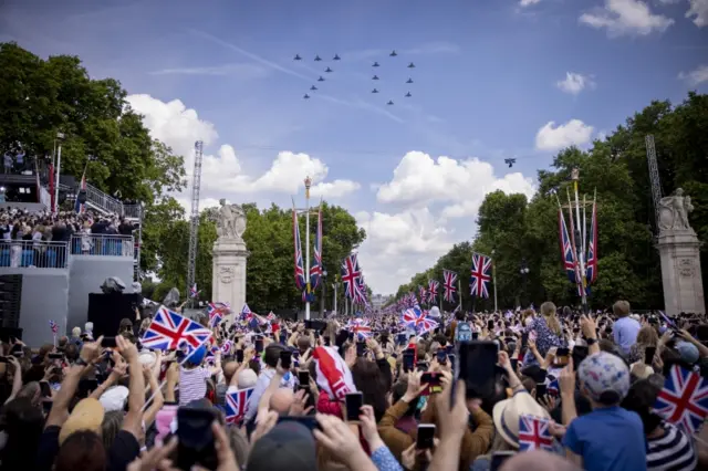 Crowds watch fighter jets from the RAF fly in formation to form the number 70 in London