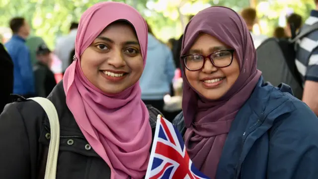 Members of the public Shazmiya Firdaus and Salamath Silmy pose with a Union Jack flag