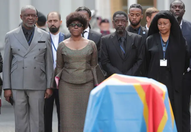 Roland, Juliana and Francois Lumumba, children of late Patrice Lumumba, the first democratically elected prime minister of Congo, stand before their father's coffin during a ceremony in Brussels, Belgium, 20 June 2022.