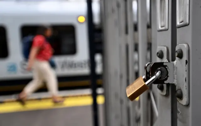 Padlocked gate at a train station