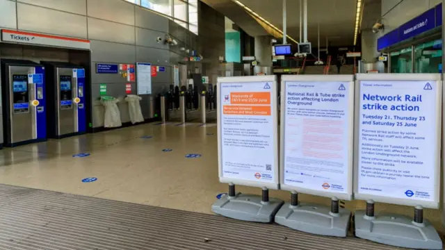 An information board informs passengers about railways strike at the entry of Shoreditch High Street station in east London