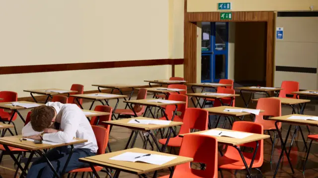 A student at a desk in a school hall