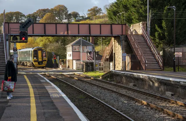 A train approaches a station in Devon