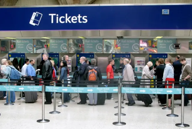 People queuing at a train ticket office