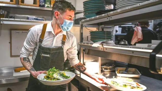 A waiter collects plates in a restaurant