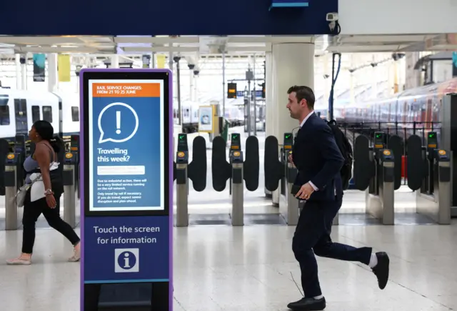 A passenger runs to catch a train at Waterloo station before train service ends early, on the first day of national rail strike in London