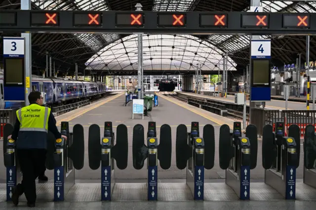 Staff are seen at a deserted Queen Street station in Glasgow