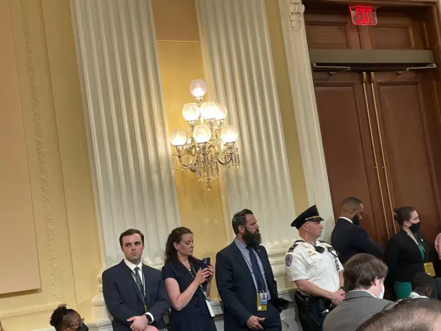 A guard stands watch over a committee hearing