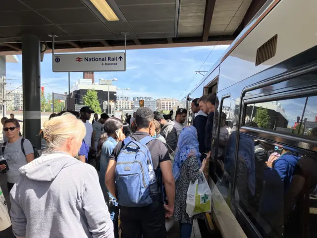 Passengers pile on to a carriage at Stratford