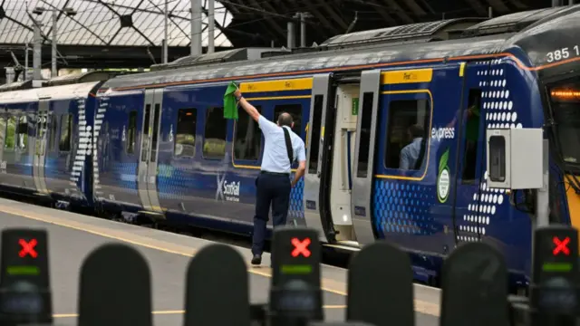 A train conductor gives a train clearance to go