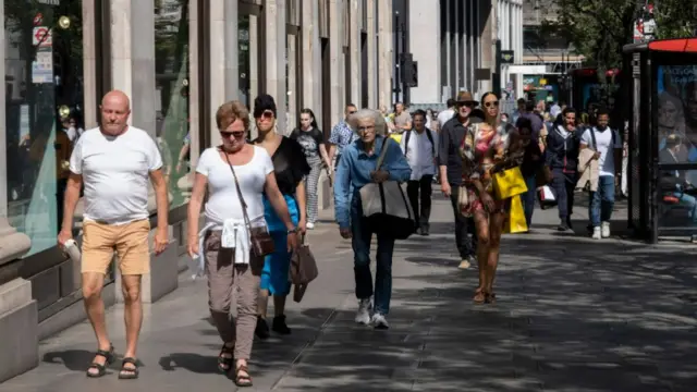 Members of the public walk down London's Oxford Street