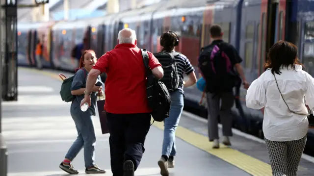 Passengers run to catch a train at Waterloo station