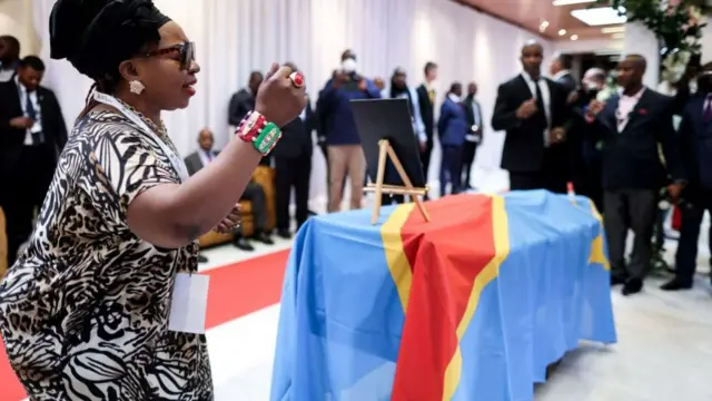 A woman pays her respects next to the coffin of Patrice Lumumba