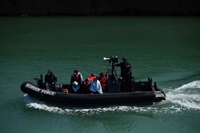 Migrants are seen on the UK Border Force rubber dinghy in the English channel