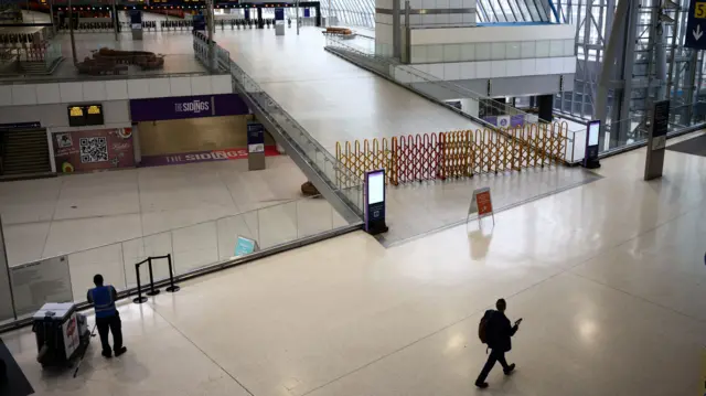 A commuter walks past a closed concourse inside Waterloo station